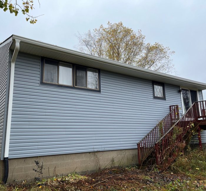 White gutter on blue house installed by Gutter Solutions of Lake Erie
