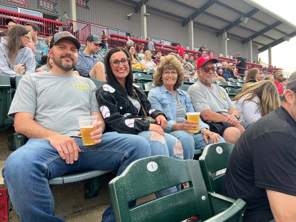 Bauer worker and family enjoying drinks and a baseball game