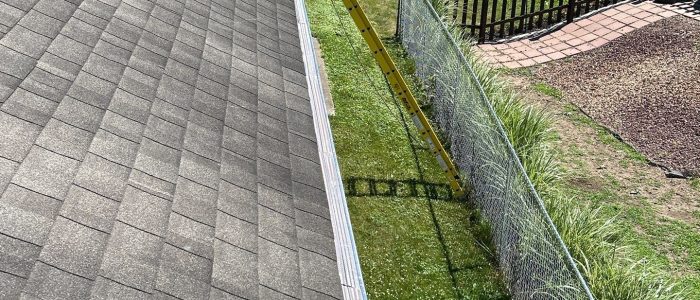 Klean Gutter on roof with ladder