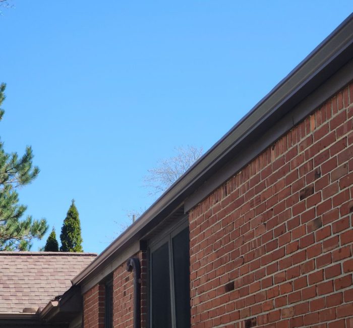 Brown gutters on brick house installed by Gutter Solutions of Lake Erie