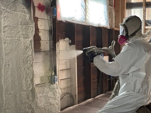 A professional contractor, from Bauer Specialty, spraying foam insulation in the walls of an Erie, PA home.